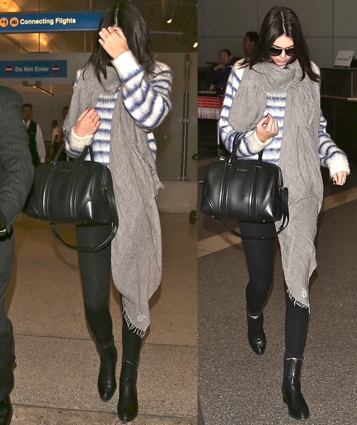 Kendall Jenner, battling acne, pairs Alexander Wang boots with black leggings, a striped mohair HM sweater, a gray scarf, and a Givenchy duffel at LAX