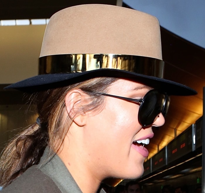 Khloé Kardashian tops her LAX travel look with a two-tone Maison Michel fedora finished with a gleaming gold band
