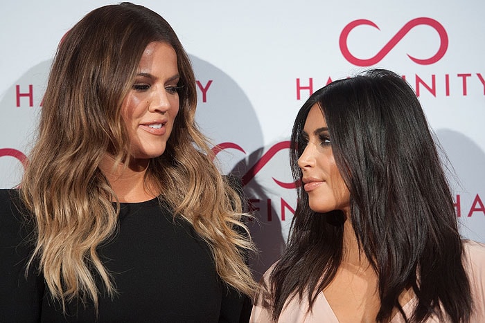Sisters Khloé and Kim Kardashian modeling their Hairfinity Hair Vitamins–infused tresses