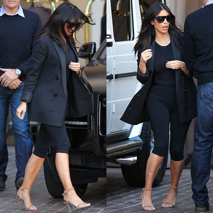 Kim Kardashian steps out in Beverly Hills wearing a sleek all-black look featuring a longline blazer, cropped leggings, and beige Alexander Wang “Antonia” sandals