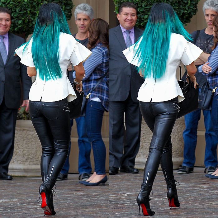 Kylie Jenner wearing a structured white Storets “Oh My Neoprene” top, edgy Zara faux-leather biker trousers with zips, a Givenchy croc-embossed Antigona duffel, and Christian Louboutin “Mado” lace-up ankle boots
