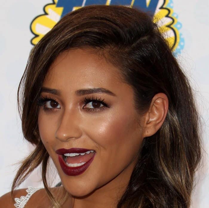 Shay Mitchell dazzles at the Teen Choice Awards with her bold makeup look, featuring striking dark red lips, dramatic eyelashes, and perfectly contoured eyes that accentuate her natural beauty