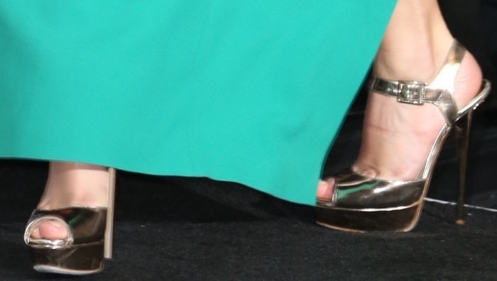 Taylor Swift's metallic Jimmy Choo platform sandals peeked out beneath her custom emerald Michael Kors gown, with the mirror-finish leather, slim ankle straps, and towering stiletto heels adding a subtle flash of glamour