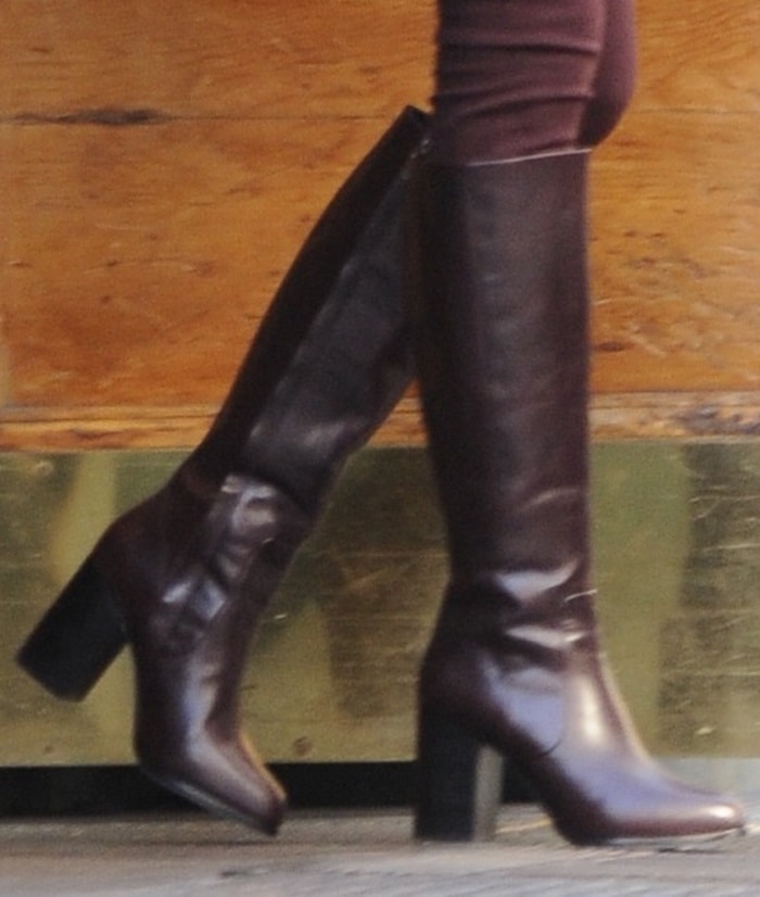 Taylor Swift steps out in sleek burgundy knee-high boots from Other Stories, featuring a block heel and minimalist silhouette perfect for fall styling