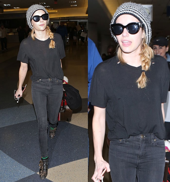 Emma Roberts in a striped knit beanie, oversized sunglasses, black T-shirt, and dark skinny jeans at LAX