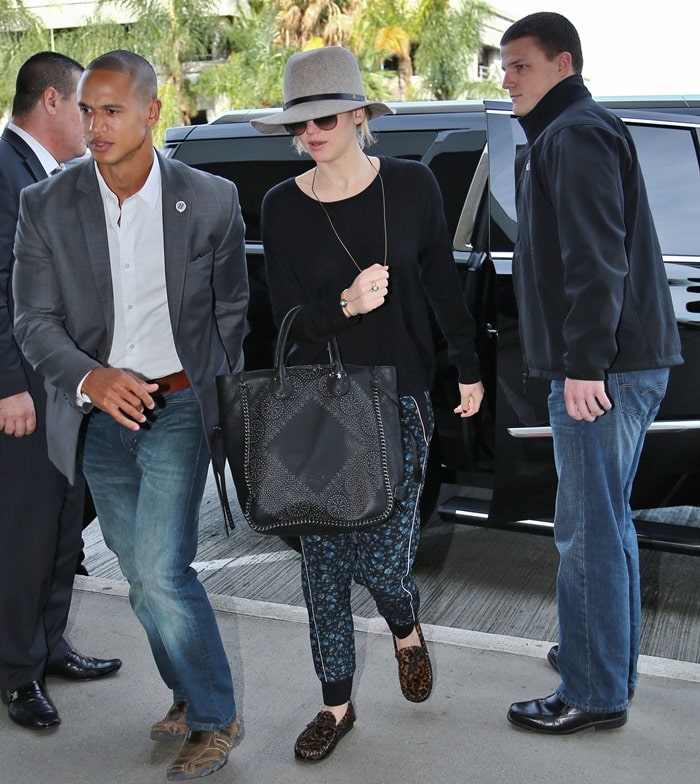 Jennifer Lawrence keeps her airport look practical in leopard-print Isabel Marant moccasins, choosing easy slip-on flats that balance travel comfort with a touch of personality through their textured calf-hair finish and bold animal-print pattern