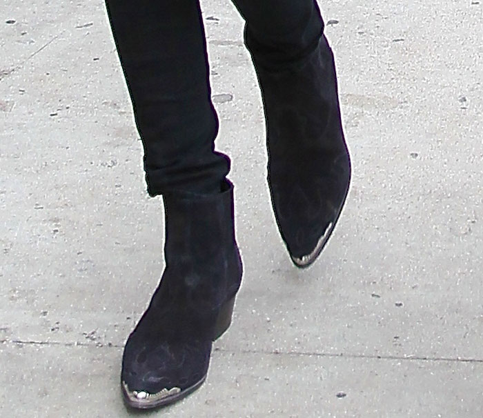 Close-up of Kendall Jenner's black suede Saint Laurent Duckies Western ankle boots with silver metal toe caps