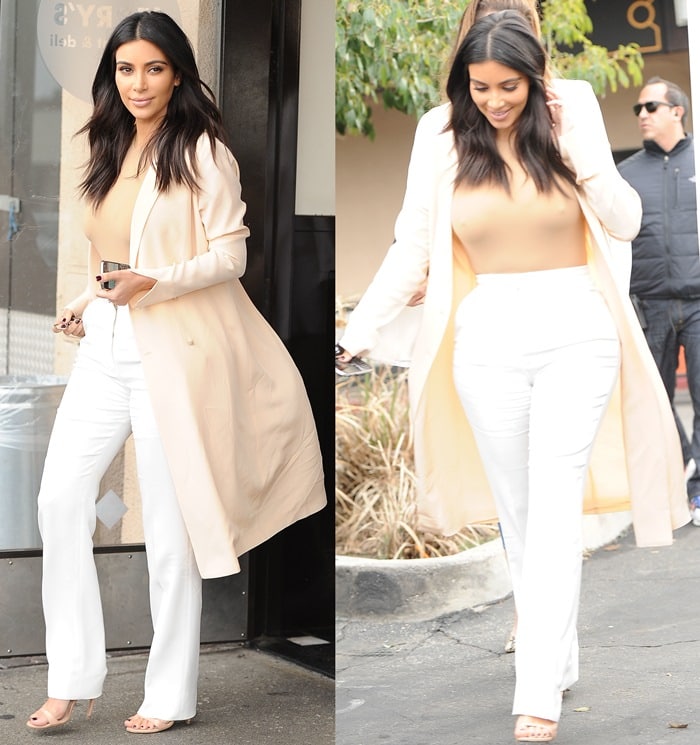 Kim Kardashian in her monochrome look, featuring a nude bodysuit, white Stella McCartney trousers, a cream coat, and Prada ankle-strap sandals