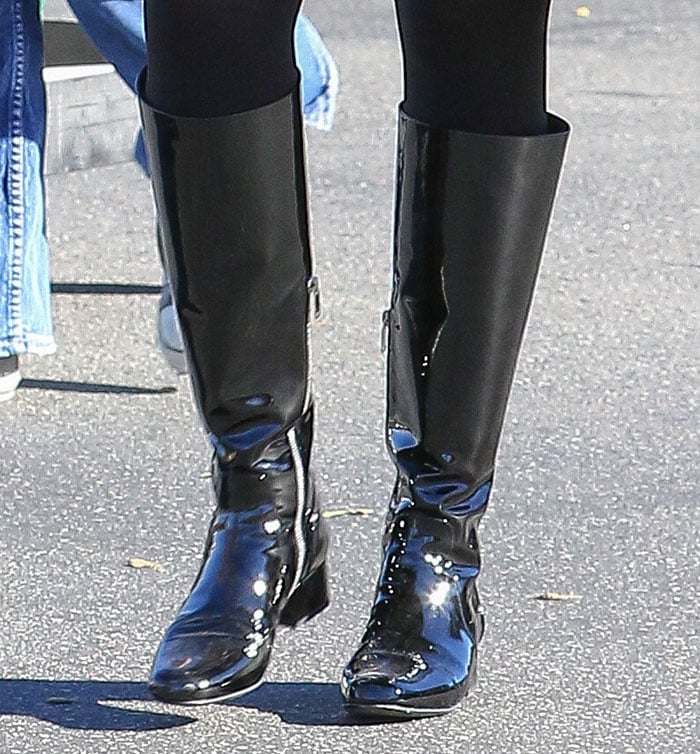 Close-up of Jenner’s Saint Laurent “Babies” boots showcasing their high-gloss patent finish, inner zippers, and tapered toes