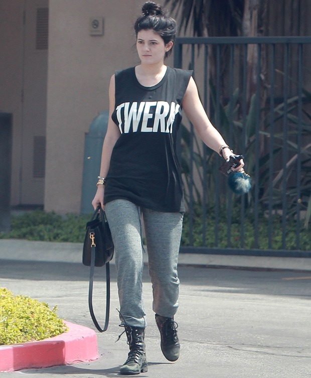 Kylie Jenner wears a black Twerk tank, gray sweatpants, and Steve Madden Troopa combat boots while leaving a gym in Los Angeles