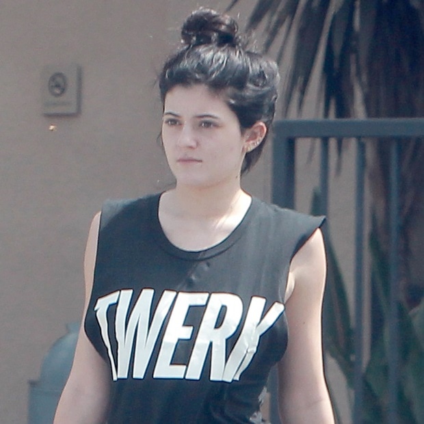 Kylie Jenner wearing an oversized black Twerk muscle tank with her hair in a topknot