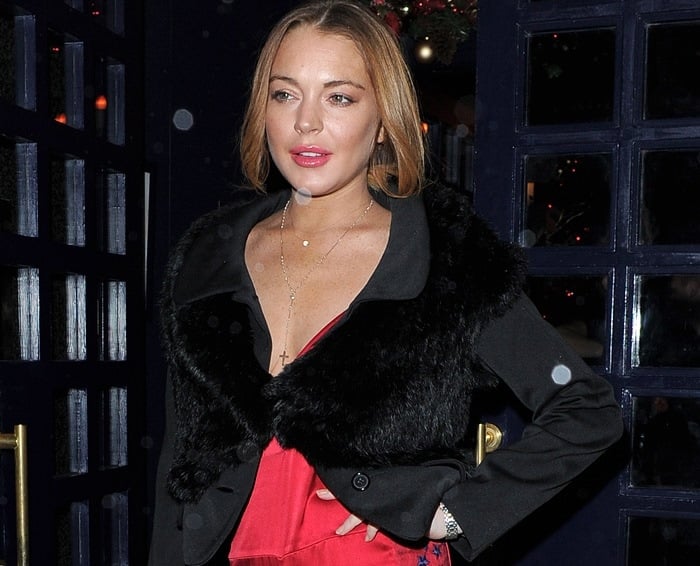 Lindsay Lohan glows in a red jumpsuit and black furry jacket at the Sunday Times Style Xmas Party in London