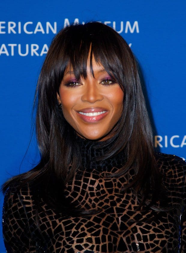Naomi Campbell wore her hair sleek and straight with chic bangs, while her makeup featured bold, purple eyeshadow that accentuated her eyes and a soft, glossy lip color