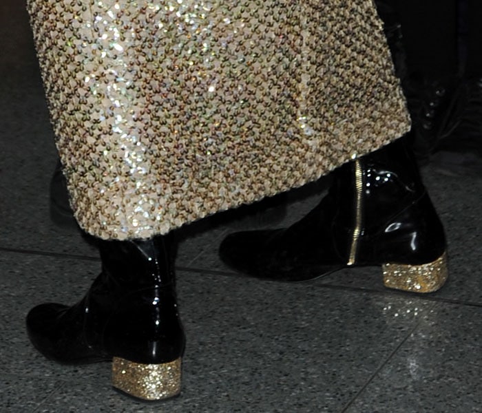 Pixie Lott's black patent boots with partial golden zipper fastenings