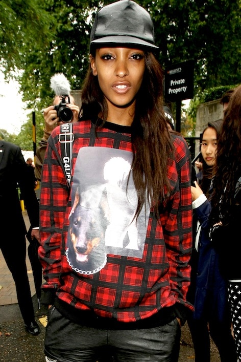 A closer view highlights Jourdan Dunn’s oversized menswear-inspired Givenchy sweatshirt, styled with a leather cap and relaxed proportions for an effortless off-duty aesthetic
