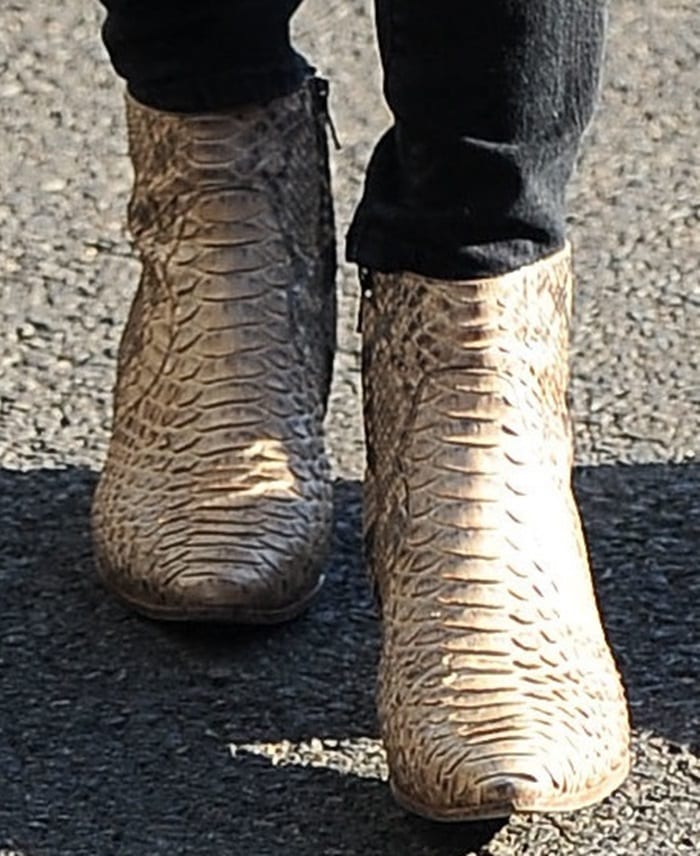 Close-up of Kendall Jenner's beige and brown Saint Laurent python Rock ankle boots with black skinny jeans