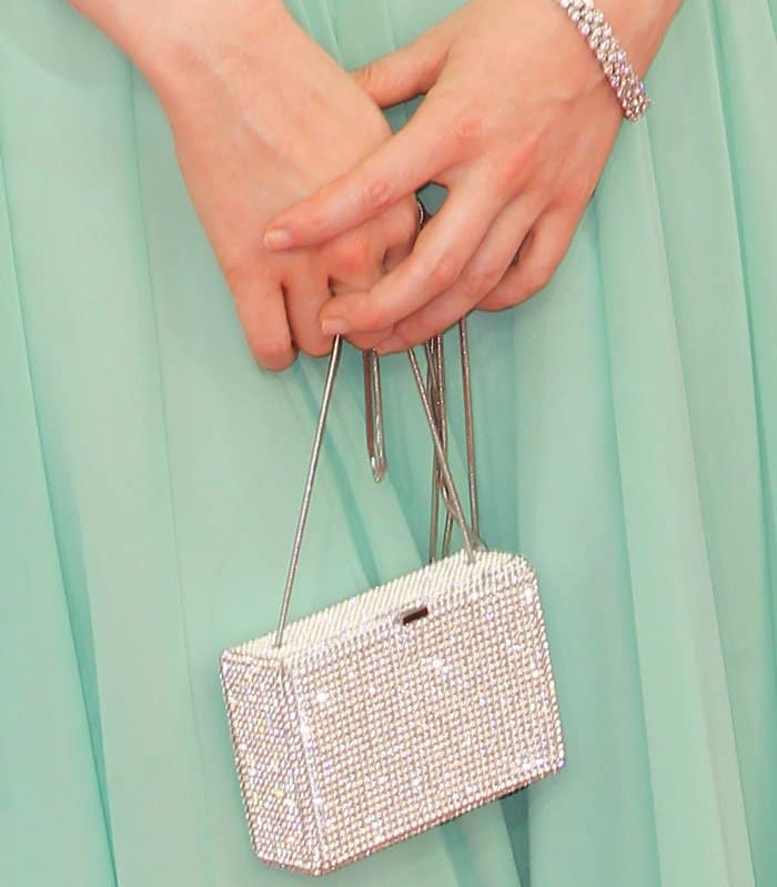Andrea Riseborough highlights her look with a sparkling Swarovski crystal clutch, adding a touch of glamour to her ensemble