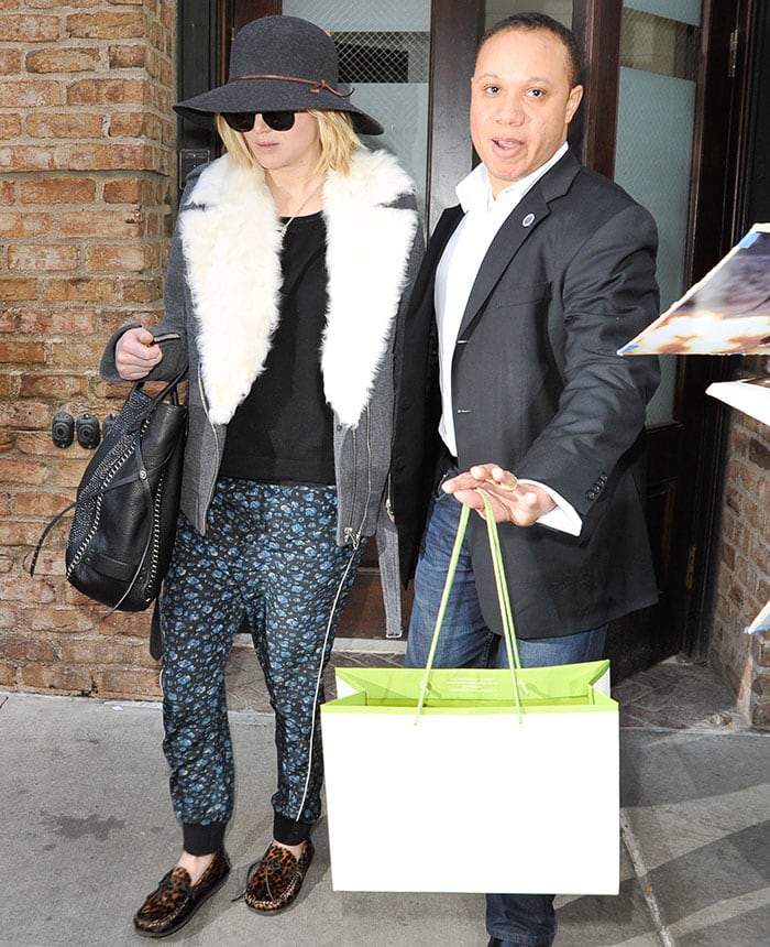 Jennifer Lawrence pairing Pam Gela printed pull-on pants with Isabel Marant leopard-print moccasins, a cozy IRO shearling coat, a Rag Bone wide-brim hat, and a studded Coach tote