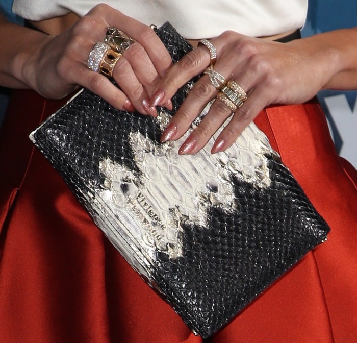 Jennifer Lopez accessorized her retro-glam ensemble with stacked diamond and gold cocktail rings while carrying a textured black-and-white Vivienne Westwood clutch
