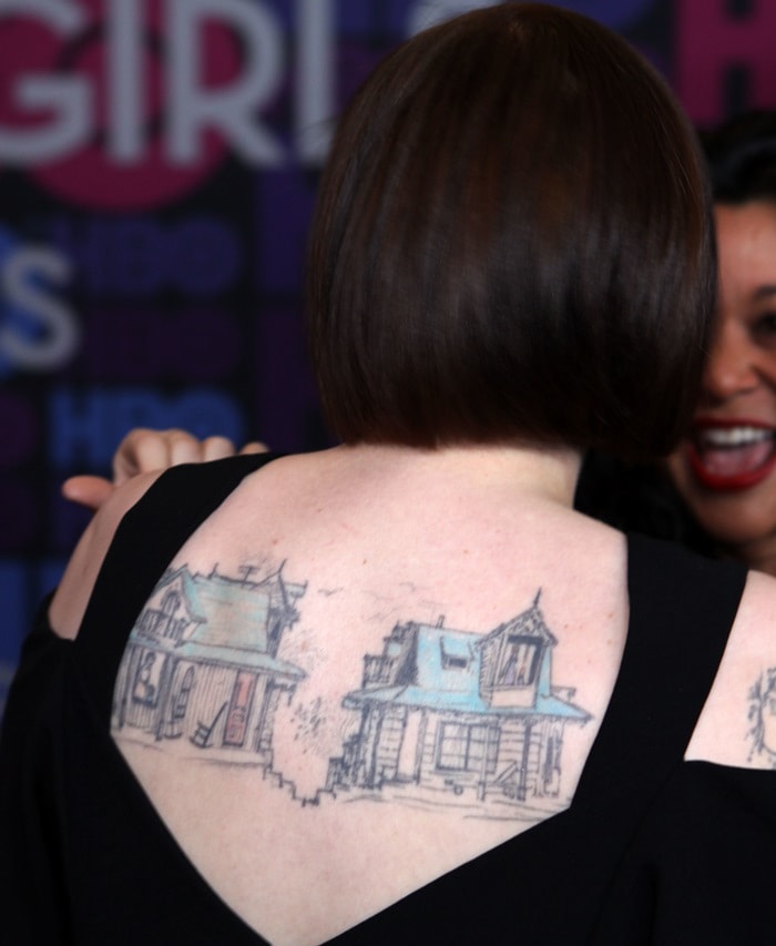 The open-back silhouette revealed Dunham's striking tattoo of two weathered houses stretching across her upper back