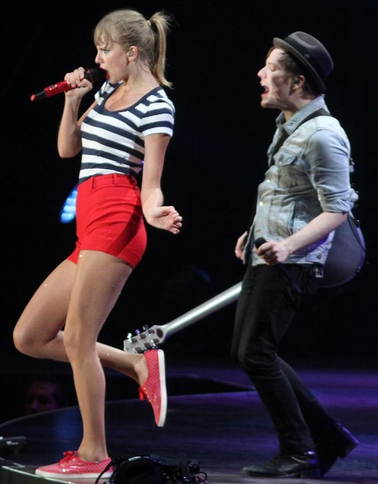Taylor Swift coordinates perfectly in vibrant red high-waist shorts and matching sneakers