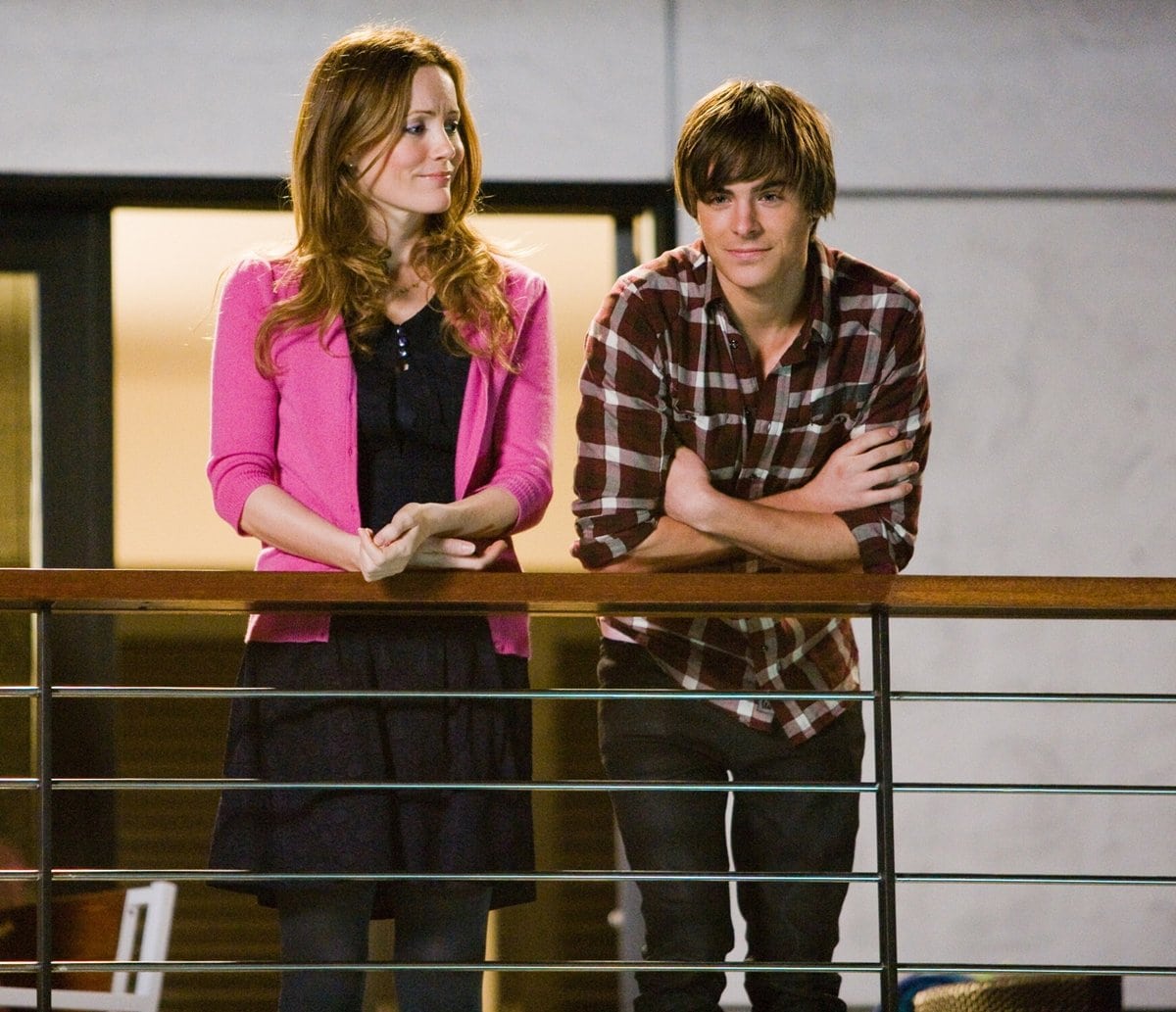 Leslie Mann softens her look with a bright pink cardigan over a navy dress, while Zac Efron keeps it casual and youthful in a laid-back plaid shirt and dark jeans