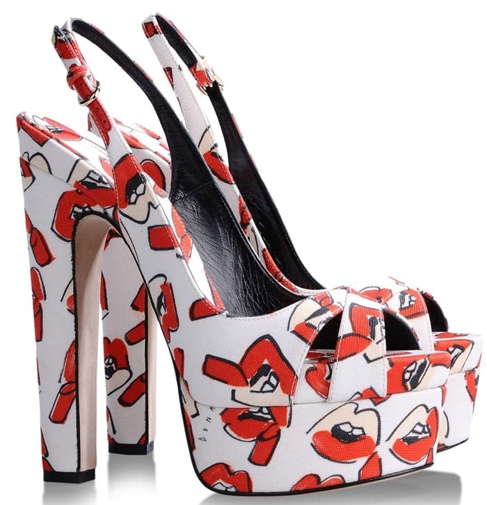 The Brian Atwood platform sandals stand out with a white canvas base splashed in illustrated red lips, combining art-driven design with sky-high glamour