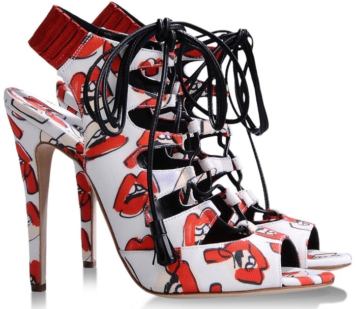 This lace-up stiletto sandal features the same illustrated red-lip print but appears in a different, strappier silhouette, distinguishing it from the platform version worn by Miley Cyrus at the event