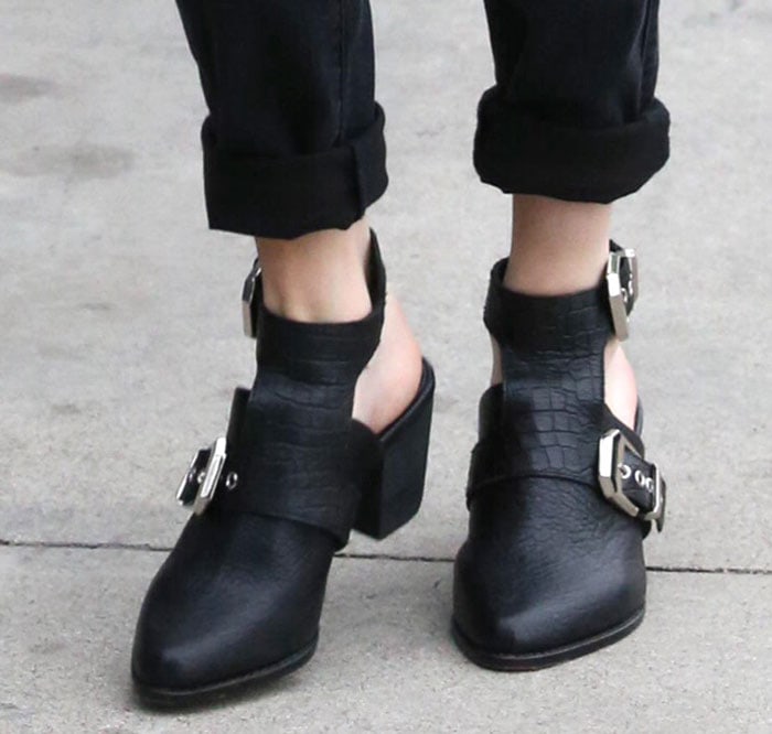 A close-up of Emma Roberts' feet in the Sol Sana "Malvin" booties, showcasing the crocodile-embossed straps and chunky block heels