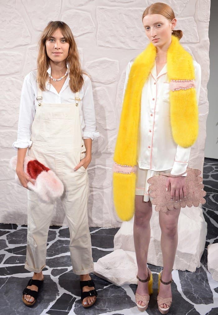 Alexa Chung keeps the focus on her pink Shrimps "Daisy" faux-fur clutch by pairing it with relaxed white overalls and classic black Birkenstock sandals at the Shrimps runway show