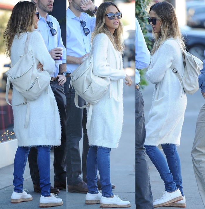 Jessica Alba masters effortless street style in a long white cardigan, slim blue jeans, and sleek white AGL brogues, paired with a minimalist backpack