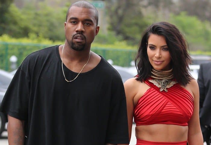 Kim Kardashian debuts her chic new short haircut while wearing a striking red Balmain ensemble, accompanied by Kanye West in a casual black outfit at the Roc Nation Pre-Grammy Brunch