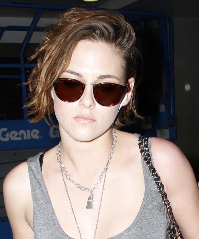 Kristen Stewart pairs her edgy "Punk Lock" necklace with a casual gray tank top and stylish sunglasses