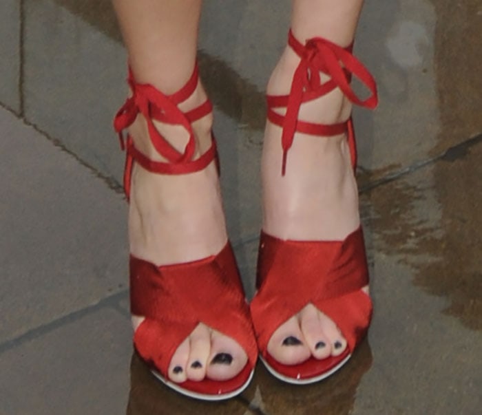 A front view of Pixie Lott’s red Topshop Unique heels shows the folded textile straps and lace-up ankle ties that completed her preppy Fashion Week look