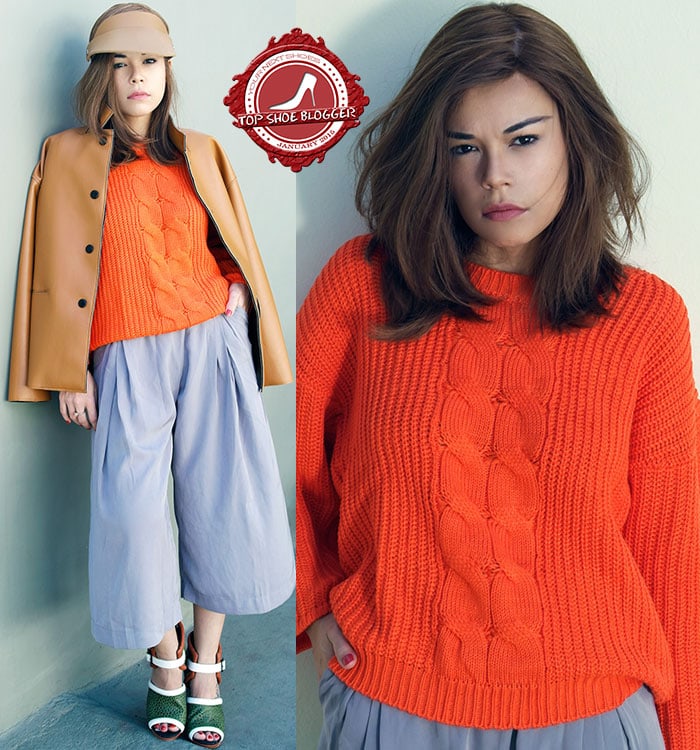 Priscila wears a bright orange sweater and gray culottes
