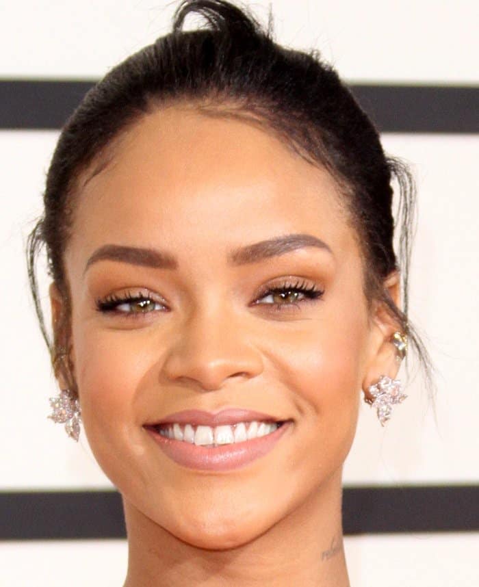 Rihanna radiates with a bright smile and elegant diamond earrings at the 2015 Grammy Awards