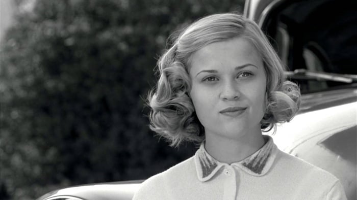 A black-and-white close-up highlights Reese Witherspoon as Jennifer in Pleasantville, capturing the polished, confident exterior of the shallow, popular, and outgoing teenager before her character’s gradual awakening disrupts the town’s perfect façade