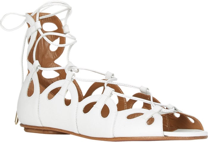 Aquazzura’s “J’Adore” sandals feature a sculptural series of teardrop cutouts and delicate wraparound laces, giving the classic flat a refined, feminine edge