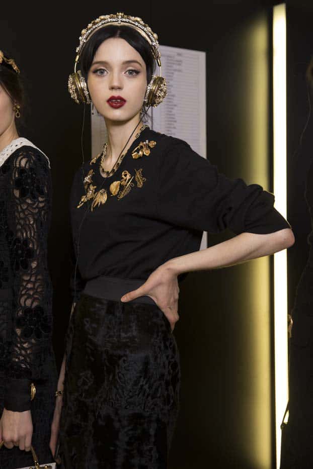 Model showcases Dolce  Gabbana's luxurious, stone-embellished headphones at a fashion event, blending high fashion with cutting-edge audio technology