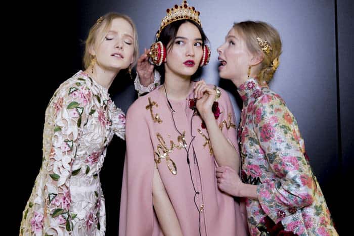Models display Dolce  Gabbana's red nappa leather headphones adorned with Swarovski crystals and pearls backstage at the Fall 2015 show in Milan
