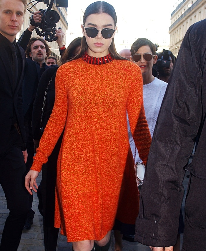 Hailee makes a bold entrance in her textured orange Dior dress, finishing the look with dark shades and minimalist styling