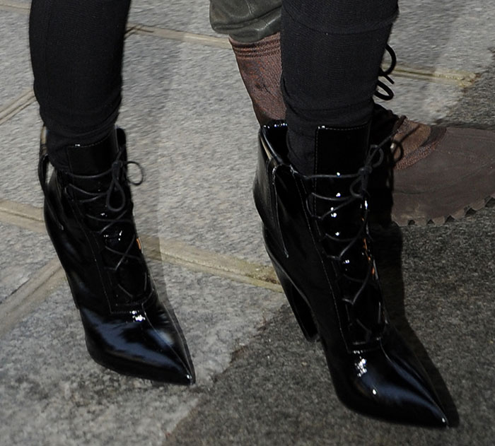 Close-up of Kim Kardashian’s glossy black Givenchy Pre-Fall 2015 lace-up pointed-toe boots, featuring sharp stiletto heels and a sculptural curved silhouette