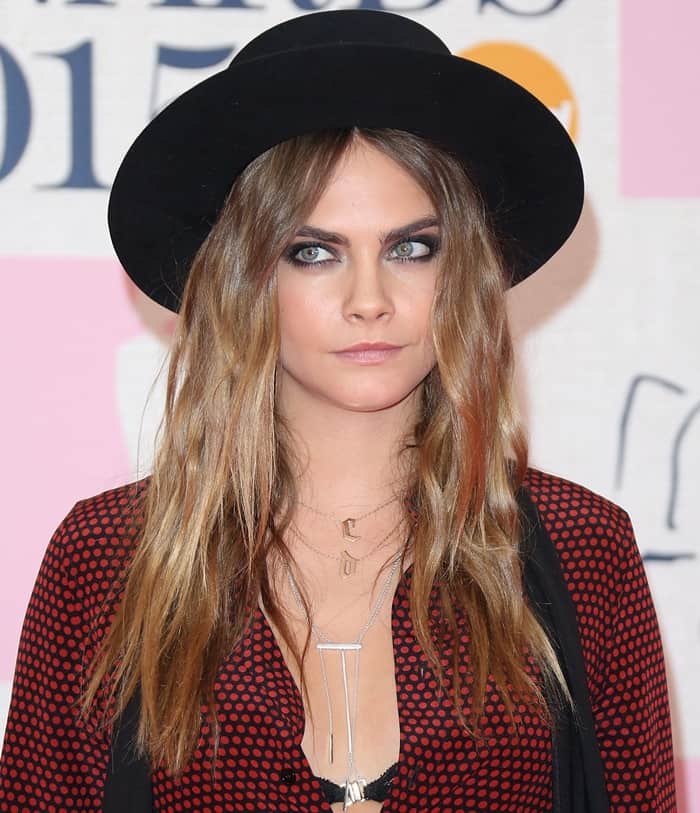 Cara Delevingne shows off her thin-strand jewelry and C D initial necklace