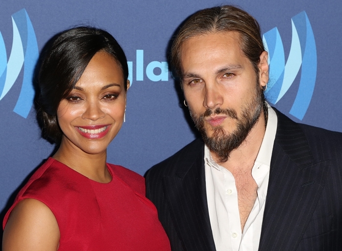 Zoe Saldaña and Marco Perego pose stylishly at the 2015 GLAAD Media Awards, with Zoe glowing in red and Marco complementing her in a sleek black pinstripe suit