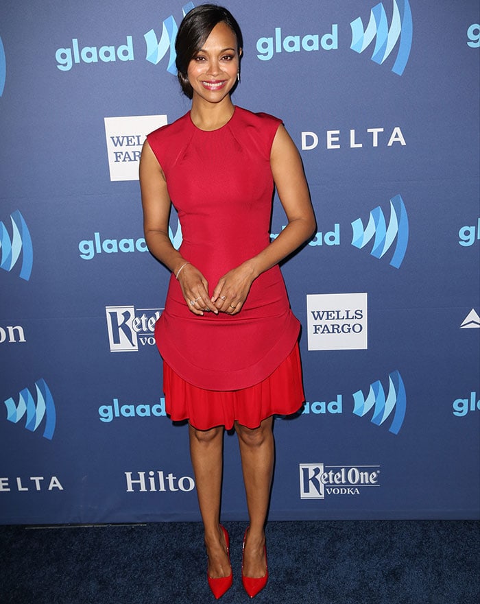 Zoe Saldaña stuns in a two-tone red Cushnie et Ochs dress paired with matching red Kurt Geiger pumps, completing her look with minimal jewelry and a sleek updo