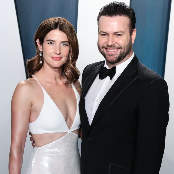 Wedded Bliss: Cobie Smulders and Taran Killam exude timeless Hollywood elegance, with Cobie dazzling in a white plunging gown and her husband looking sharp in a classic tuxedo