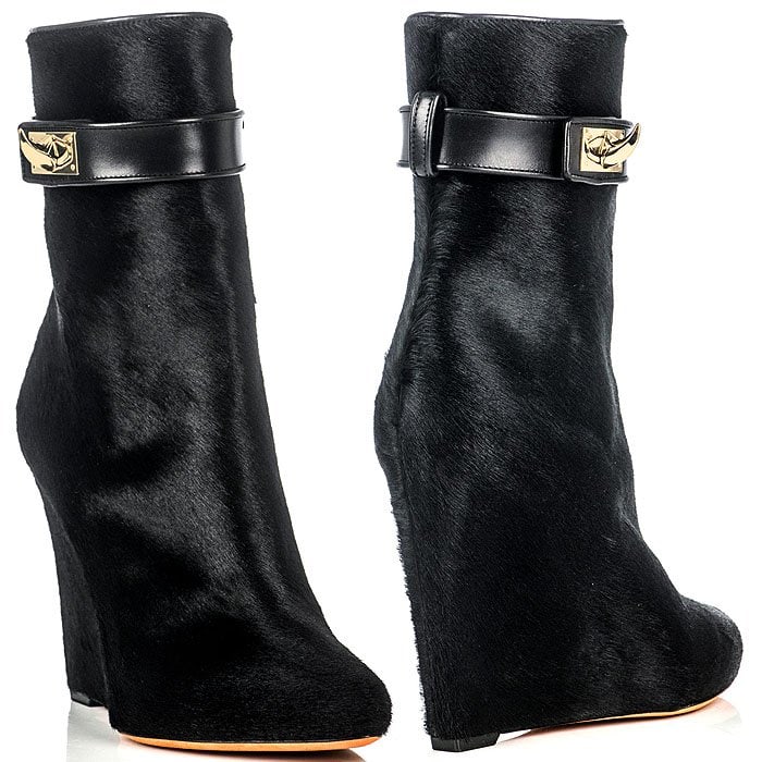 Givenchy’s pony-hair sharktooth ankle boots feature a sculptural wedge heel, slouched silhouette, and gold-tone buckle detail, delivering a bold fusion of luxury texture and architectural edge