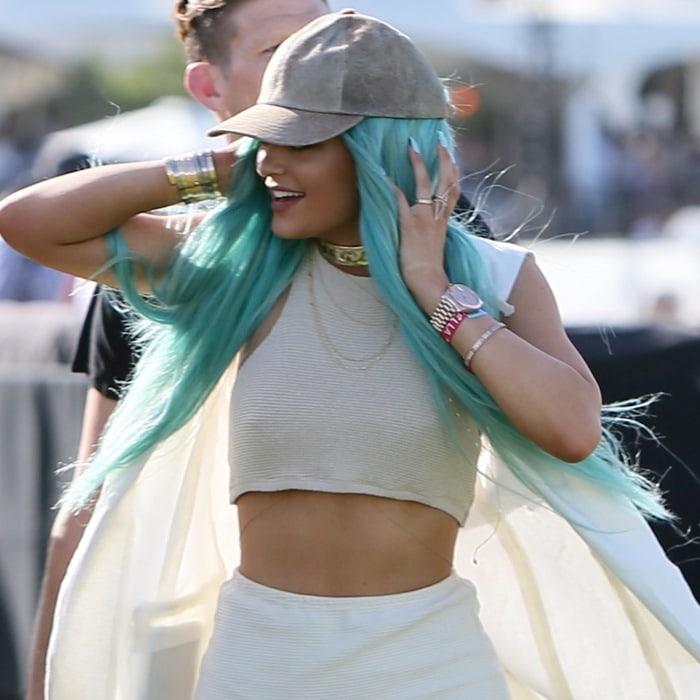 Kylie Jenner showcasing her striking aqua hair and a ribbed knit halter top paired with a long, flowing waistcoat at Coachella 2015