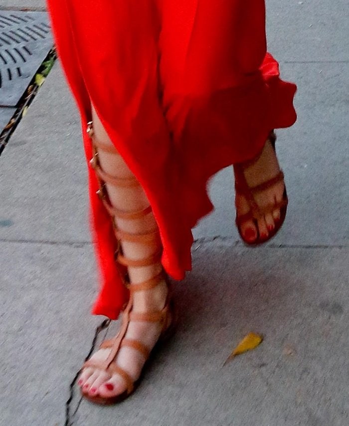 Bella Thorne steps out in stylish tan Schutz gladiator sandals featuring multiple buckles and a knee-high design