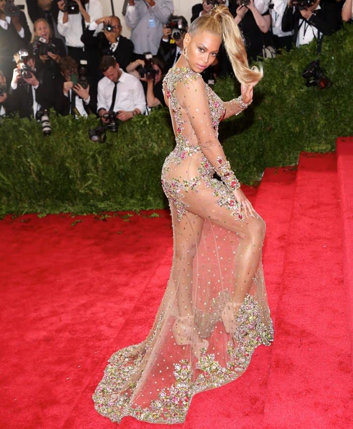 Beyoncé strikes a confident pose in her sheer Givenchy Couture dress, embellished with multicolored gemstones, at the 2015 Met Gala